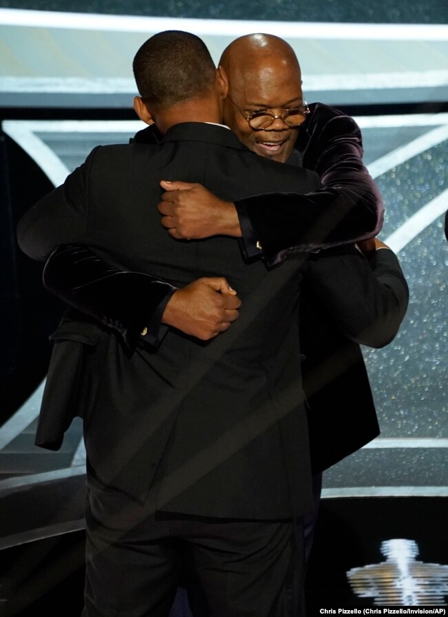 Will Smith, left, and Samuel L. Jackson hug in the audience as Will Smith is announced the winner of the award for best performance by an actor in a leading role for "King Richard" at the Oscars on Sunday, March 27, 2022.