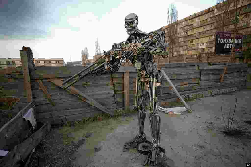 A depiction of the Terminator, made from automobile transmission parts, is placed near a checkpoint in Kyiv, Ukraine.
