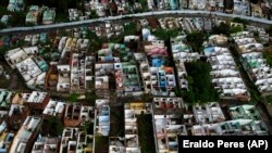 Homes stand abandoned in Maceio, Alagoas state, Brazil, Sunday, March 6, 2022. The homes have been abandoned because of the threat of ground subsidence caused by the Braskem mine that has forced more than 55 thousand people from their homes. (AP Photo/Eraldo Peres)