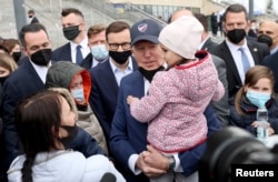 조 바이든(가운데) 미국 대통령이 26일 폴란드 바르샤바 PGE 국립경기장에서 우크라이나 피란민들을 만나고 있다.
