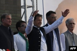 Pakistan's Prime Minister Imran Khan, center, gestures upon his arrival to address the supporters of ruling Pakistan Tehreek-e-Insaf (PTI) party during a rally in Islamabad, March 27, 2022.