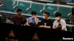 People sit in an area where relatives of the passengers of the China Eastern Airlines Boeing 737-800 plane, which crashed in Wuzhou flying from Kunming to Guangzhou, wait for news, at Guangzhou Baiyun International Airport in Guangzhou, Guangdong province, China, March 21, 2022. 