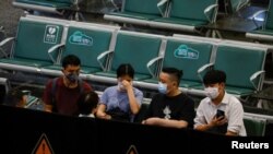 People sit in an area where relatives of the passengers of the China Eastern Airlines Boeing 737-800 plane, which crashed in Wuzhou flying from Kunming to Guangzhou, wait for news, at Guangzhou Baiyun International Airport in Guangzhou, Guangdong province