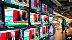 2022年2月24日，香港，人们站在播放着俄罗斯军队对乌克兰发动攻击的新闻的电视屏幕前。（美联社）