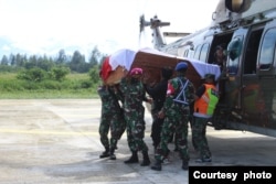 Para anggota TNI membawa peti berisi jenazah rekannya yang gugur dalam serangan yang dilakukan oleh kelompok bersenjata di Nduga, Papua, dalam proses evakuasi menuju Timika, pada 27 Maret 2022. (Foto: Pendam XVII/Cenderawasih Papua)