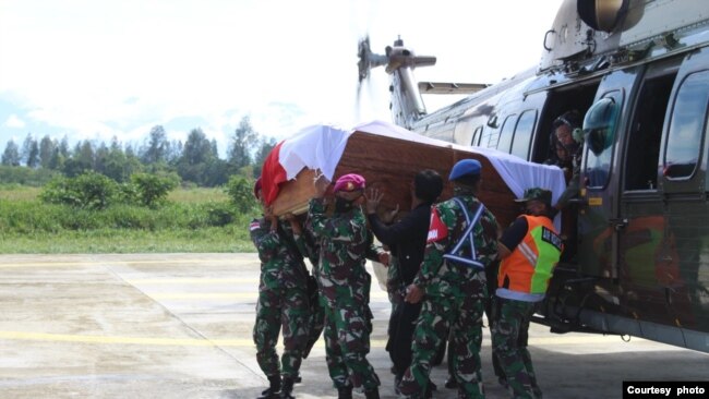 Para anggota TNI membawa peti berisi jenazah rekannya yang gugur dalam serangan yang dilakukan oleh kelompok bersenjata di Nduga, Papua, dalam proses evakuasi menuju Timika, pada 27 Maret 2022. (Foto: Pendam XVII/Cenderawasih Papua)