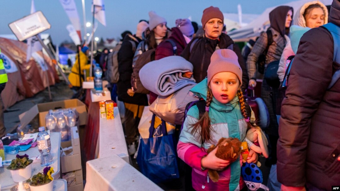A little girl is seen as people line up to board buses at the Medyka Polish-Ukrainian border crossing on March 18, 2022.