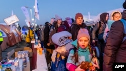 A little girl is seen as people line up to board buses at the Medyka Polish-Ukrainian border crossing on March 18, 2022.