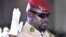 Le chef de la junte guinéenne, le colonel Mamady Doumbouya, lève la main lors de sa prestation de serment en tant que président de la transition du pays, le 1er octobre 2021 à Conakry. (Photo AFP/ Cellou BINANI)