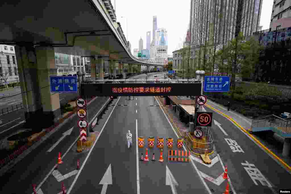 A worker in a protective suit walks at an entrance to a tunnel leading to the Pudong area across the Huangpu river, after restrictions on highway traffic amid the lockdown to contain the spread of COVID-19 in Shanghai, China.