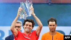 Taylor Fritz of the US lifts the championship trophy beside Rafael Nadal of Spain following their ATP Men's Final at the Indian Wells tennis tournament on March 20, 2022, in Indian Wells, California.