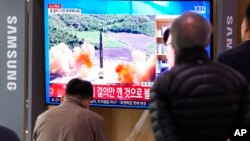 24일 한국 서울역 이용객들이 북한 미사일 발사 뉴스를 시청하고 있다.