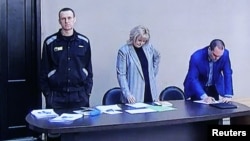 El opositor ruso Alexei Navalny, acusado de fraude y desacato al tribunal, y sus abogados vistos en una pantalla a través de un enlace de video durante una audiencia judicial en la colonia penal correccional IK-2 en Pokrov, Rusia, el 22 de marzo de 2022.
