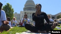 Ratusan praktisi melakukan Yoga di lapangan gedung Capitol Washington DC hari Sabtu (16/6).