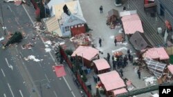 German Chancellor Angela Merkel and other government members visit the site of the attack in Berlin, Germany, Dec. 20, 2016, the day after a truck ran into a crowded Christmas market and killed several people. 