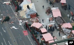 FILE - German Chancellor Angela Merkel and other government members visit the site of the attack in Berlin, Germany, Dec. 20, 2016, the day after a truck ran into a crowded Christmas market and killed several people.