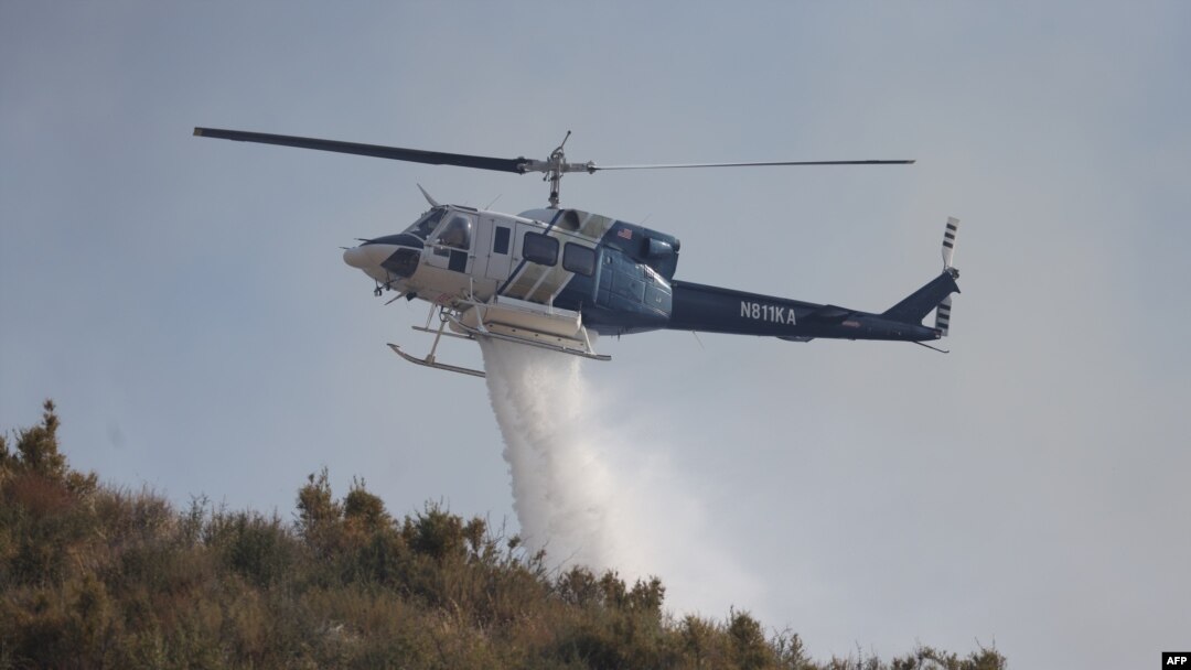Arhiva - Vatrogasni helikopter izbacuje vodu na požar u Soledad kanjonu, nedaleko od Akva Dolčea, Kalifornija, 25. jula 2023.
