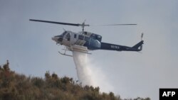 Arhiva - Vatrogasni helikopter izbacuje vodu na požar u Soledad kanjonu, nedaleko od Akva Dolčea, Kalifornija, 25. jula 2023.