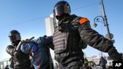 Police officers detain a man during a protest against the jailing of opposition leader Alexei Navalny in Vladivostok, Russia, on Sunday, Jan. 31, 2021. As part of a multipronged effort by the authorities to discourage Russians from attending Sunday…