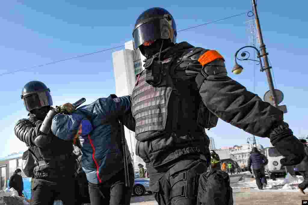 Police officers detain a man during a protest against the jailing of opposition leader Alexei Navalny in Vladivostok, Russia.