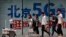 人们在北京街头一个购物区的5G网络广告前走过。（2019年5月15日）