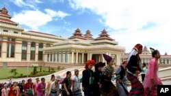 Myanmar's youth dressed in different ethnic minorities' attires walk to Myanmar's parliament to attend a function to mark the International Day of Democracy in Naypyidaw, Myanmar, Tuesday, Sept. 15, 2015. More than 90 political parties will take part in the parliamentary election