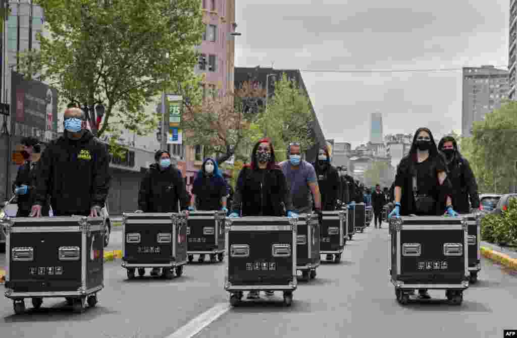 Members of the Arts and Shows Association Union (AGTAE) march pushing boxes with lights and wires during a protest demanding the government of Chilean President Sebastian Pinera for support since they have been inactive for months due to the COVID-19 pandemic, in Santiago, Sept. 29, 2020.