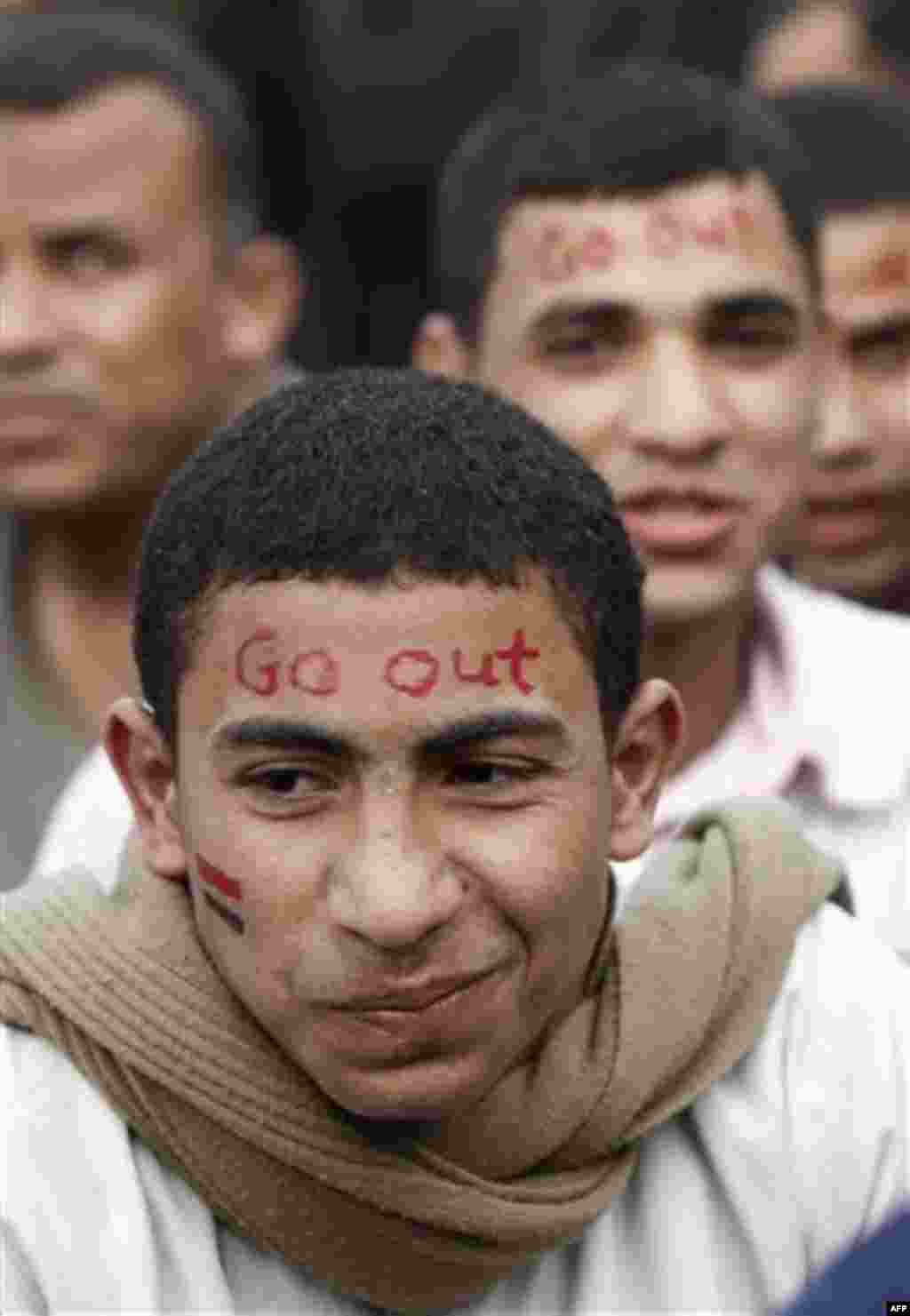 Anti-government protesters with slogans and national flags painted on their faces sit in Tahrir, or Liberation Square in Cairo, Egypt, Tuesday, Feb. 1, 2011. More than a quarter-million people flooded into the heart of Cairo Tuesday, filling the city's ma