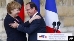 German Chancellor Angela Merkel, and French President Francois Hollande react after a speech in front of the Reims cathedral in Reims, eastern France, July 8, 2012. 