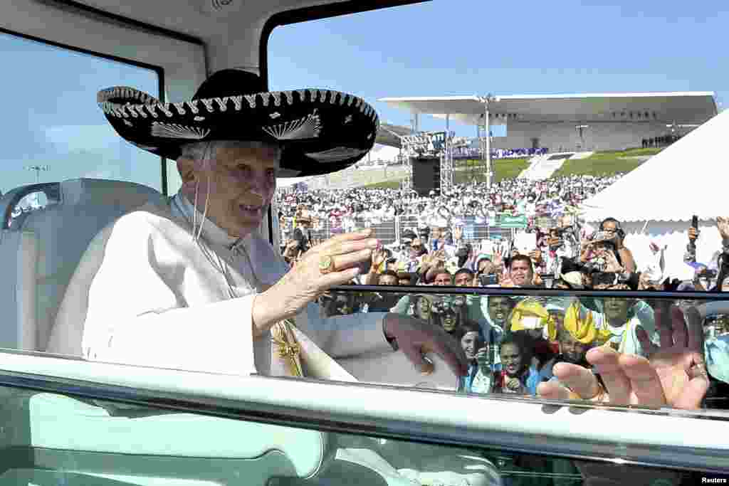 Pope Benedict wears a sombrero, a traditional Mexican hat, while being driven through the crowd before officiating a mass in Silao, Mexico, March 25, 2012. 