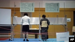 ٹوکیو کے ایک پولنگ اسٹیشن میں لوگ ووٹ ڈال رہے ہیں