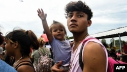 Honduran migrants taking part in a caravan heading to the US, arrive at the border crossing point with Mexico, in Ciudad Tecun Uman, Guatemala, Oct. 19, 2018.