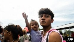 Honduran migrants taking part in a caravan heading to the US, arrive at the border crossing point with Mexico, in Ciudad Tecun Uman, Guatemala, on Oct. 19, 2018.