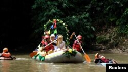 Novanto Rahman dan pasangannya, Sandra Fidelia Novianti, yang bekerja sukarela dalam inisiatif pembersihan Ciliwung, melangsungkan upacara pernikahan mereka di sungai itu (18/12). (Reuters/Adi Kurniawan)