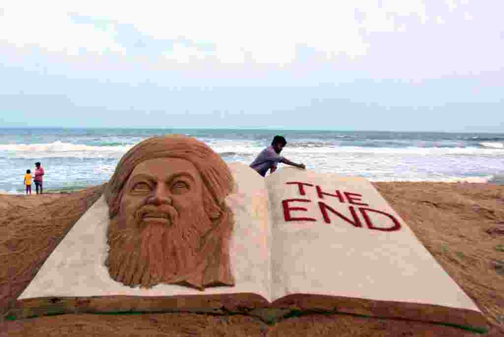 Seorang artis pembuat patung dari pasir dari India, Sudarshan Pattnaik, menciptakan karyanya menandai tewasnya Osama bin Laden, di Orissa, India, 2 May 2011 (AP)