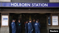 London Underground workers stand outside Holborn Station, which was closed following a fire alert, in central London, Aug. 15, 2017.