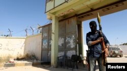 An Islamist fighter guards the entrance to the February 17 militia camp after Libyan irregulars clashed with them in the eastern city of Benghazi, May 16, 2014.