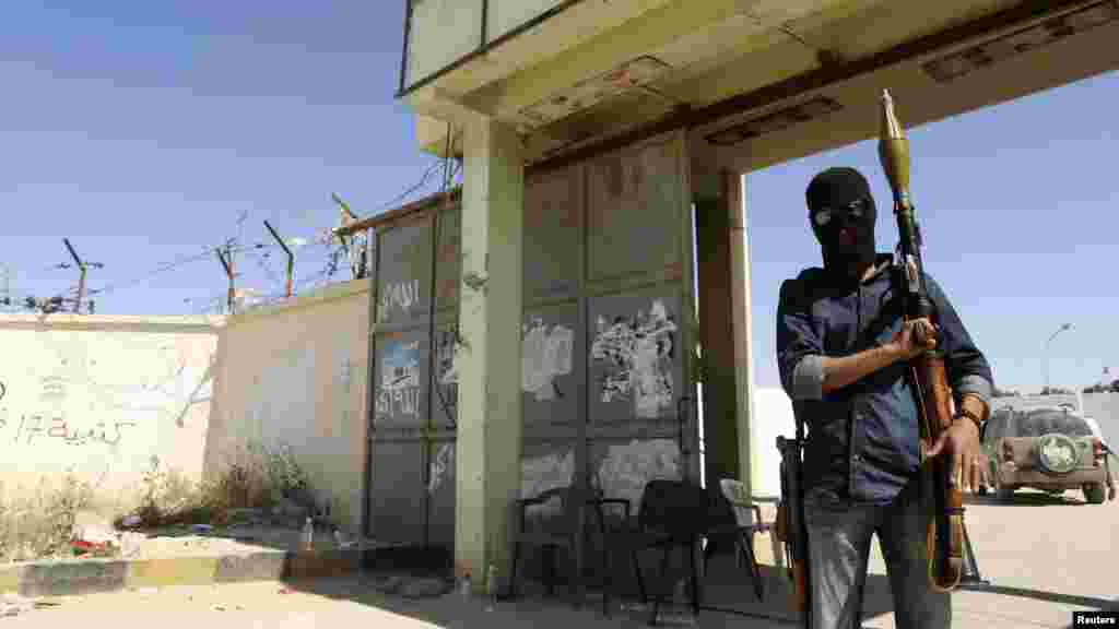 An Islamist fighter guards the entrance to the February 17 militia camp after Libyan irregulars clashed with them in the eastern city of Benghazi, May 16, 2014.