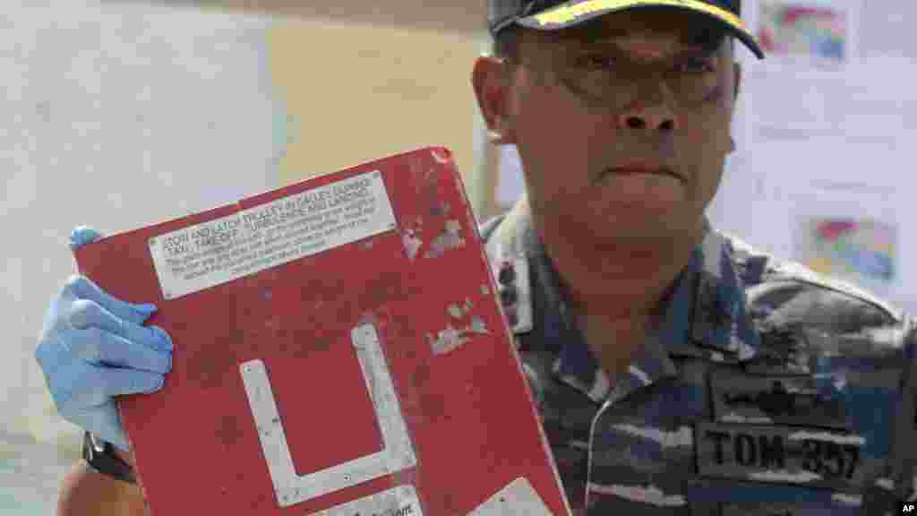 Le commandant de la marine indonésienne,&nbsp;du navire KRI Bung Tomo, le colonel Yayan Sofyan tient un morceau de l'avion d'AirAsie récupéré dans les opérations de recherche, lors d'une conférence de presse à Surabaya, East Java, en Indonésie, 5 janvier 2015.