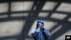 Un trabajador en traje protector se prepara en un sitio de test de coronavirus en Beijing el 5 de diciembre de 2022.