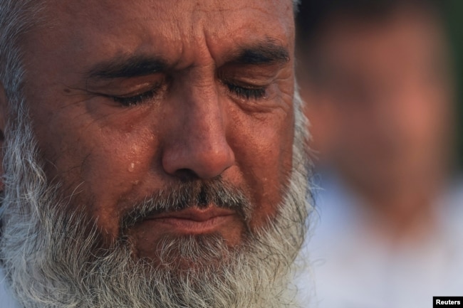 A man mourns as he attends funeral prayers in absentia after the assassination of Hamas leader Ismail Haniyeh in Iran, in Peshawar, Pakistan, July 31, 2024.