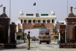 FILE - An Indian border security force soldier stands guard as an Indian truck, exporting goods to Pakistan, returns back towards the Indian side of joint check post between India and Pakistan at Wagah, India.