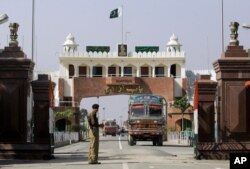 FILE - An Indian border security force soldier stands guard as an Indian truck, exporting goods to Pakistan, returns back towards the Indian side of joint check post between India and Pakistan at Wagah, India.