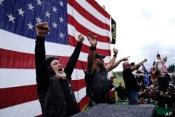 Miembros de los Proud Boys reaccionan con júbilo durante una manifestación de grupos de derecha en Portland Oregon,el sábado.
