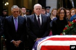 Los exdirectores de la CIA, George Tenet (izq.) y John Brennan, junto a la actual directora de la agencia Gina Haspel, rinden tributo al expresidente George H.W. Bush, cuyo cuerpo en un ataúd cubierto con la bandera de EE.UU. yace en capilla ardiente en el Capitolio de la nación. Dic. 4 de 2018.