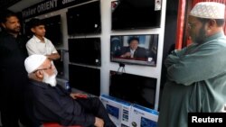 Shopkeepers watch the speech of Pakistani Prime Minister Imran Khan, after Pakistan shot down two Indian military aircrafts, at a shop selling television screens in Karachi, Pakistan, Feb. 27, 2019.