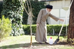 IRAN -- Iranian Supreme Leader Ayatollah Ali Khamenei uses protective gloves as he attends a tree planting ceremony in Tehran, March 3, 2020