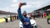 El piloto Bubba Wallace se toma un "selfie" luego que otros pilotos y trabajadores de la pista empujaran su auto al frente de la línea de inicio, en un acto de solidaridad tras encontrar una soga que se creyó había sido un amenaza de muerte racista.