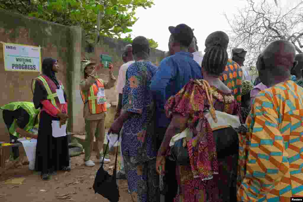 A member of the National Youth Service Corps (NYSC) takes a photograph of a voter using Bimodal Voter Accreditation System (BVAS) during Nigeria&#39;s Presidential election, in Lagos, Nigeria February 25, 2023.&nbsp;