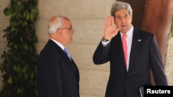 U.S. Secretary of State John Kerry (R) waves as he stands next to Palestinian Chief Negotiator Saeb Erekat before his meeting with Palestinian President Mahmoud Abbas in the West Bank city of Ramallah May 23, 2013.